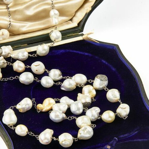 Lunga collana in oro bianco brunito intercalato da perle barocche con inserti in pavè di brillantini. Epoca anni '40