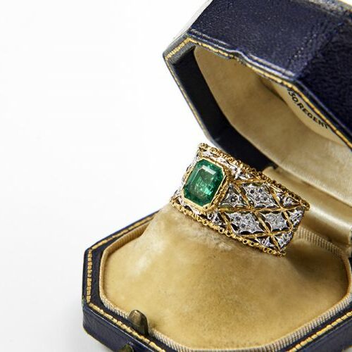 Anello a fascia traforata in oro giallo e oro bianco modello Buccellati con smeraldo e diamanti.